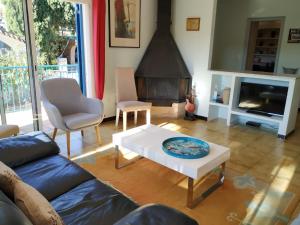 sala de estar con sofá, mesa y chimenea en VACAY Villa alzines, en L'Escala