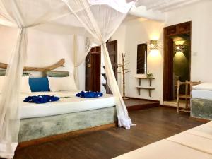 a bedroom with a bed with a canopy at Zanzistar Lodge in Jambiani