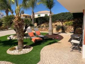 a patio with chairs and a table and palm trees at Casa Mós in Lagos