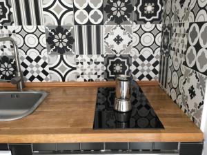 a kitchen counter with a sink and black and white tiles at La casa di Julie in Ronchi dei Legionari