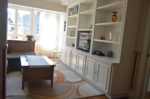 a living room with white cabinets and a tv at Casa acogedora in Mundaka +22 photos