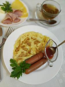 a plate of food with two hot dogs and omelet at Predslava Hotel in Kyiv