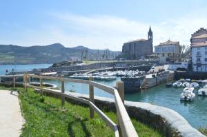 a marina with boats in the water and buildings at Casa acogedora in Mundaka