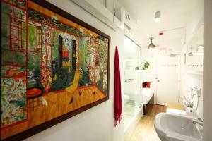 a bathroom with a large painting on the wall at Apple lnn Causeway Bay in Hong Kong