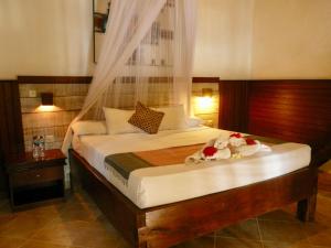 Un dormitorio con una cama con flores. en Wawa Wewe II Villas, en Amed