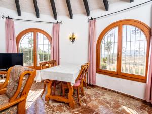 jadalnia ze stołem, krzesłami i oknami w obiekcie Holiday Home Zindel by Interhome w mieście Balcon del Mar