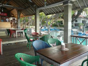 un patio al aire libre con mesas y sillas y una piscina en Wawa Wewe II Villas, en Amed