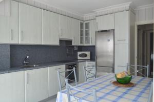 a kitchen with white cabinets and a table with a bowl on it at Casa acogedora in Mundaka