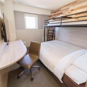 Schlafzimmer mit einem Schreibtisch und einem Etagenbett in der Unterkunft Super Hotel Kushiro Natural Hot Spring in Kushiro
