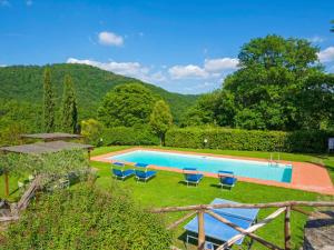 una piscina con sillas azules en el césped en Holiday Home La Pieve by Interhome en Lucolena in Chianti