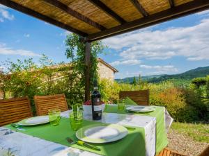 a table with plates and a bottle of wine on it at Holiday Home La Torre by Interhome in Lucolena in Chianti