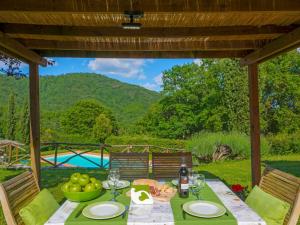 a table with food and a view of a pool at Holiday Home I Lecci by Interhome in Lucolena in Chianti