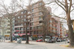 un gran edificio en una calle de la ciudad con coches aparcados delante en GLORIOUS - 2-Bedroom apartment near Youth Hill, en Plovdiv