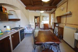 a kitchen with a wooden table and a dining room at Spoleto by the pool in Spoleto