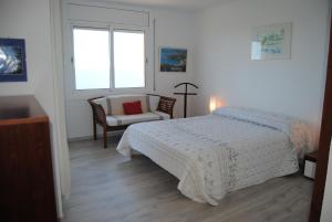 a bedroom with a bed and a chair and a window at Legroux - 373 in Llafranc