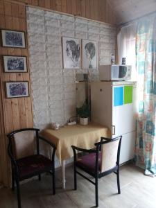 eine Küche mit einem Tisch, 2 Stühlen und einem Kühlschrank in der Unterkunft Diofa apartman in Abda
