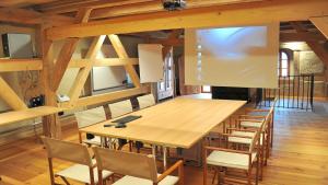 een eetkamer met een grote houten tafel en stoelen bij Schlosshotel Betzenstein in Betzenstein