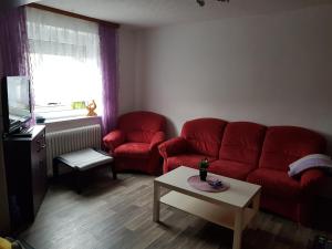 a living room with a red couch and a table at Ferienwohnung Eliah in Rust