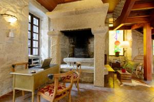 a living room with a stone fireplace and a desk with a laptop at Casa do Marqués in Baiona