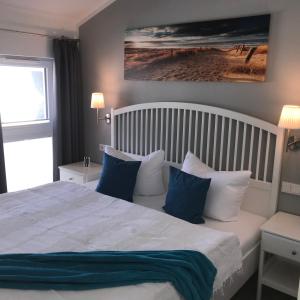 a bedroom with a bed with blue and white pillows at Ferienwohnung Oberdeck 2.06 in Glowe
