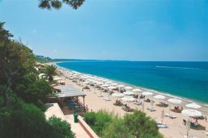a beach with umbrellas and chairs and the ocean at Hotel Fotini in Mytikas