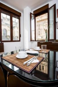 a dining room table with plates and utensils on it at Apartamentos Casa de la Lonja in Granada
