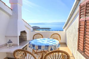 a table and chairs on a balcony with a view of the ocean at Apartment Galerija by El-Pi Tours in Njivice