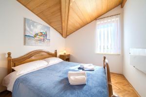 a bedroom with a blue bed and a window at Apartment Galerija by El-Pi Tours in Njivice