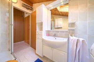 a white bathroom with a sink and a shower at Apartment Galerija by El-Pi Tours in Njivice +22 photos