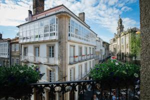 a large white building with windows on a city street at Hotel Arco de Mazarelos in Santiago de Compostela