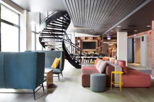 a living room with couches and a spiral staircase at Comfort Hotel Bergen in Bergen
