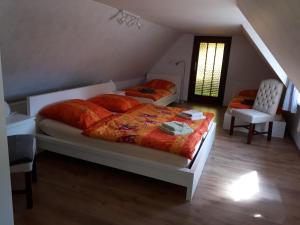 1 dormitorio con 2 camas, silla y ventana en Ferienhaus Luise, en Sebnitz