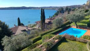 an aerial view of a house with a swimming pool and a lake at casa amigo in Padenghe sul Garda