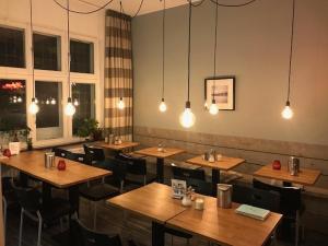 a restaurant with wooden tables and chairs and lights at B&B De Hofnar Maastricht in Maastricht
