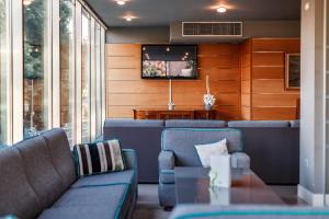 a living room with couches and a tv on a wall at Caravel Bike Hotel in Nago-Torbole