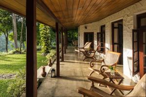 a porch with rocking chairs on a house at Rosyth Estate House in Pinnawala