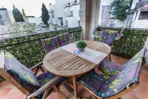 Villa Danile Cosy Apartments في بودفا: طاولة وكراسي خشبية على شرفة