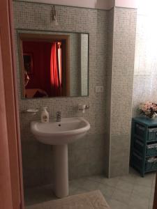a bathroom with a sink and a mirror at Appartamento l’Akorea in Convento +17 photos