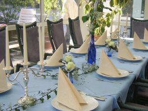 una mesa con un mantel azul con botes de papel. en Hotel-Pension Haus Hubertus, en Weigendorf