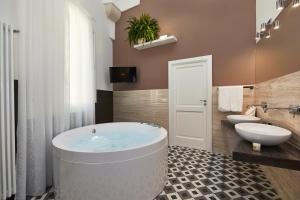 a bathroom with a tub and a toilet and a sink at Donna Teresa Guest House in Lecce