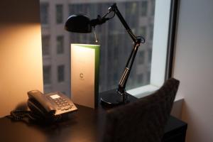 a lamp sitting on top of a desk next to a window at CitiClub Hotel Melbourne in Melbourne