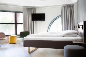 a bedroom with a large bed with a tv on it at Comfort Hotel Bergen in Bergen