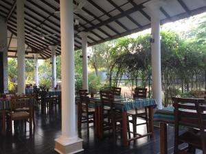 a row of tables and chairs under a pavilion at Goddess Garden Sigiriya in Sigiriya