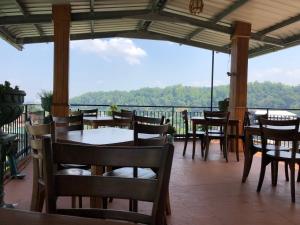 a restaurant with tables and chairs on a balcony at Sharon Inn in Kandy