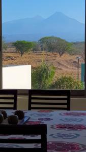 a dining room with a table and a view of a field at Suites Lagunas in Colima