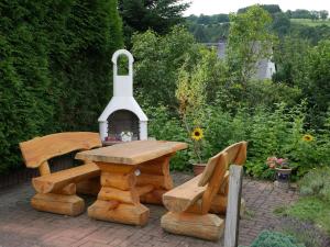 a wooden table and two chairs and a table and bench at Beautiful Apartment in P hla Saxony near Ski Area in Pöhla