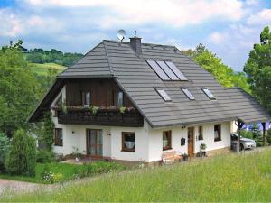 a small white house with a black roof at Beautiful Apartment in P hla Saxony near Ski Area in Pöhla