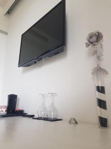 TV de pantalla plana colgada en la pared en Agriturismo La Torretta, en Pescantina