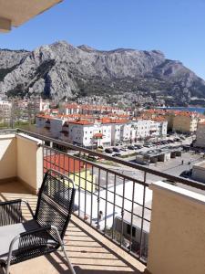 una sedia seduta su un balcone con vista sulla città di Apartment Zdravko - with parking a Omiš (Almissa)