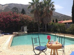 a table and chairs next to a swimming pool at Hotel Aura in Vulcano